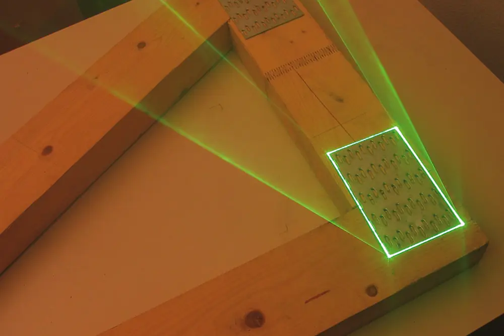 Template positioning on prefabricated wooden parts with laser projection